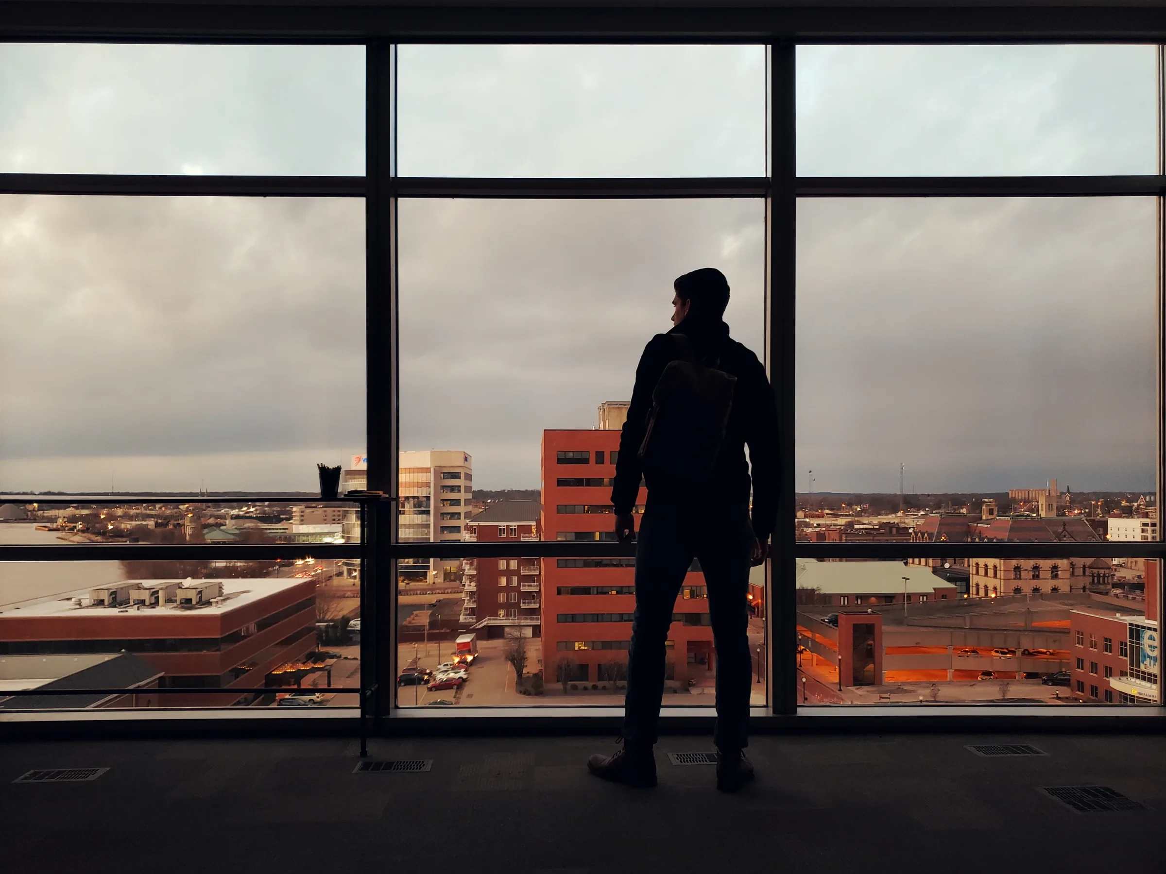 Jon Boettcher overlooking downtown Evansville through a large window